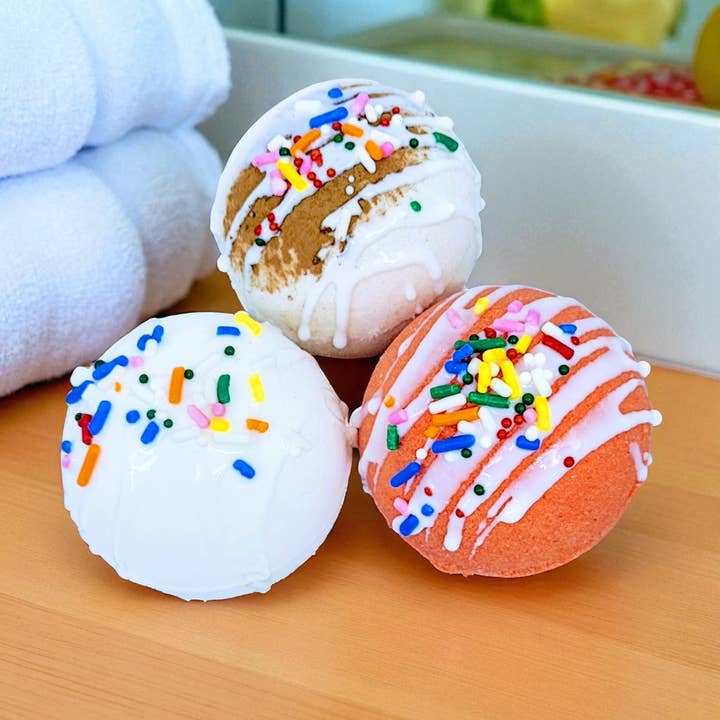 Three colorful bath bombs with sprinkles