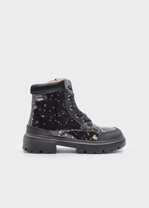 Black star-patterned boots on a light gray background